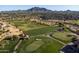 Aerial view of manicured greens and lush fairways on the golf course, nestled within a scenic residential community at 3274 E Isaiah Ct, Gilbert, AZ 85298