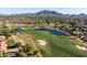 Golf course aerial view with manicured green fairways, scenic water features, and stunning mountain views in the background at 3274 E Isaiah Ct, Gilbert, AZ 85298