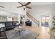 Spacious living room with wood floors seamlessly connects to the kitchen and features a staircase at 3274 E Isaiah Ct, Gilbert, AZ 85298