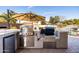 This modern outdoor kitchen features a built-in grill, storage, and counter space for poolside entertaining at 3274 E Isaiah Ct, Gilbert, AZ 85298