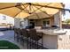 Under a wide umbrella, this outdoor kitchen is an entertainer's dream, complete with bar seating at 3274 E Isaiah Ct, Gilbert, AZ 85298