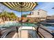 Backyard swimming pool with lounge chairs, an umbrella, and a view of the landscaped yard, great for relaxing at 3274 E Isaiah Ct, Gilbert, AZ 85298