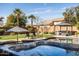 The pool and hot tub provide a luxurious retreat with palm trees and shaded seating areas for relaxation at 3274 E Isaiah Ct, Gilbert, AZ 85298