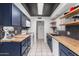 Stylish kitchen with navy cabinets, butcher block countertops, and trendy open shelving at 4022 W Kaler Dr, Phoenix, AZ 85051