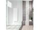 Modern walk-in shower featuring gray and white tile, a built-in bench, and sleek glass enclosure at 4455 S Matter --, Mesa, AZ 85212