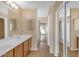 Bright bathroom featuring tiled floors, double vanity, mirrors, and walk way at 44983 W Sage Brush Dr, Maricopa, AZ 85139