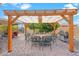 Inviting backyard patio with a wooden pergola, dining set, and barbecue grill perfect for outdoor entertainment at 4510 E Emelita Ave, Mesa, AZ 85206