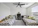 Bright bedroom featuring two twin beds, ceiling fan, and stuffed animal decor at 47558 W Mellen Ln, Maricopa, AZ 85139