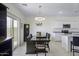 Open concept dining area with modern lighting fixture, neutral color palette, and easy kitchen access at 47558 W Mellen Ln, Maricopa, AZ 85139