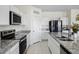 Bright kitchen featuring white cabinetry, stainless steel appliances, and stylish granite countertops at 47558 W Mellen Ln, Maricopa, AZ 85139