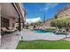 Outdoor backyard featuring a covered lounge, a barbecue, an in-ground pool with rock waterfall feature and mountain views at 4822 S Gold Canyon Dr, Gold Canyon, AZ 85118