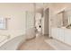 A bright bathroom featuring tile floors, vanity, soaking tub, and decorative lighting at 4822 S Gold Canyon Dr, Gold Canyon, AZ 85118