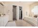 Well-lit bathroom featuring double doors, a vanity, and a luxurious soaking tub at 4822 S Gold Canyon Dr, Gold Canyon, AZ 85118