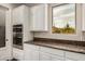 Close-up of kitchen with stainless appliances, including double oven, granite countertops and white cabinets at 4822 S Gold Canyon Dr, Gold Canyon, AZ 85118