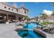 An in-ground pool and hot tub with rock waterfall feature, and covered lounge perfect for backyard entertaining at 4822 S Gold Canyon Dr, Gold Canyon, AZ 85118