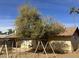 Backyard featuring a mature shade tree and a swing set, creating a playful outdoor space at 5323 W Seldon Ln, Glendale, AZ 85302