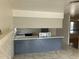 Kitchen island featuring grey cabinetry, white counter top, and double sink with a view of the living room at 5323 W Seldon Ln, Glendale, AZ 85302