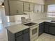 Kitchen featuring grey cabinets, white countertops, white appliances and views of the living room at 5323 W Seldon Ln, Glendale, AZ 85302