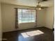 Bright living room with a ceiling fan and a large window offering a view of the swimming pool at 5323 W Seldon Ln, Glendale, AZ 85302