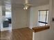 Bright living room features hardwood floors, ceiling fan, and a view into the kitchen area at 5323 W Seldon Ln, Glendale, AZ 85302