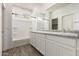 Bright bathroom features a tub, shower, and dual sinks with white cabinets at 5474 W Fulton St, Phoenix, AZ 85043