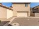 Beige two-story home featuring an attached two-car garage and low maintenance rock landscaping at 5474 W Fulton St, Phoenix, AZ 85043