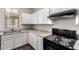 Well-lit kitchen featuring white cabinets, granite countertops, and black electric range at 5474 W Fulton St, Phoenix, AZ 85043