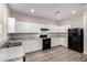 Open kitchen design with white cabinets, granite countertops, and modern black appliances at 5474 W Fulton St, Phoenix, AZ 85043