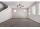 Spacious living room featuring neutral walls and carpet, large windows and a ceiling fan at 5474 W Fulton St, Phoenix, AZ 85043