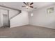 Spacious living room featuring neutral walls and carpet, large windows and a ceiling fan at 5474 W Fulton St, Phoenix, AZ 85043