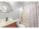 Bathroom includes a bathtub with patterned curtain, round mirror, and a standard toilet at 627 W Flower Ave, Mesa, AZ 85210