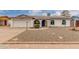 Charming home featuring a blue accent trim, solar panels, and a low-maintenance rock yard at 627 W Flower Ave, Mesa, AZ 85210