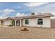 Attractive home features solar panels, gravel yard, arched windows, and a blue front door at 627 W Flower Ave, Mesa, AZ 85210