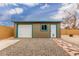 This outbuilding offers garage storage and a separate entrance with a pet door and a stone pathway at 627 W Flower Ave, Mesa, AZ 85210