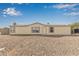 Beige single-story home featuring a desert landscape, complemented by clear, sunny skies above at 6901 W Patricia Ann Ln, Peoria, AZ 85382