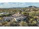 An aerial shot displays a desert home with a red tile roof, complemented by the surrounding arid landscape and distant mountains at 7363 E Lower Wash Pass, Scottsdale, AZ 85266