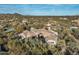 Beautiful aerial shot of a desert home with a terracotta roof, surrounded by natural vegetation, and mountain backdrop at 7363 E Lower Wash Pass, Scottsdale, AZ 85266