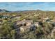 Expansive desert home aerial view with a clay tile roof, native plants, and scenic mountain panorama in the background at 7363 E Lower Wash Pass, Scottsdale, AZ 85266