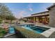 Relaxing backyard featuring a sparkling pool, spa, outdoor kitchen, and desert landscaping at 7363 E Lower Wash Pass, Scottsdale, AZ 85266