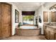 Elegant bathroom with a soaking tub, framed window, and natural light at 7363 E Lower Wash Pass, Scottsdale, AZ 85266