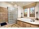 Bright bathroom showcasing a soaking tub with decorative tile and a glass block shower at 7363 E Lower Wash Pass, Scottsdale, AZ 85266