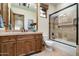 Stylish bathroom boasts wood cabinets, a large mirror, and a glass shower with tile surround at 7363 E Lower Wash Pass, Scottsdale, AZ 85266