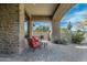 Charming covered patio featuring stone architecture and comfortable seating, ideal for enjoying the beautiful desert scenery at 7363 E Lower Wash Pass, Scottsdale, AZ 85266