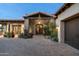 The entrance has a covered entry with stone accents and a charming front door at 7363 E Lower Wash Pass, Scottsdale, AZ 85266