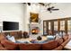 Inviting living room featuring a stone fireplace, wooden beams, and a large comfortable sofa at 7363 E Lower Wash Pass, Scottsdale, AZ 85266