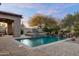 Inviting pool features a stone structure, water features, and beautiful desert landscaping at 7363 E Lower Wash Pass, Scottsdale, AZ 85266