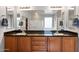 Bathroom with vanity with double sinks, dark countertops, and storage cabinets at 7387 W Remuda Dr, Peoria, AZ 85383