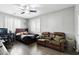 Cozy bedroom featuring a full bed, wood floors, ceiling fan, and a brown leather recliner loveseat at 7387 W Remuda Dr, Peoria, AZ 85383