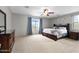 Spacious main bedroom with neutral carpet, ceiling fan, dresser and large window at 7387 W Remuda Dr, Peoria, AZ 85383