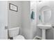 Clean powder room with a pedestal sink, toilet, and decorative art at 7387 W Remuda Dr, Peoria, AZ 85383